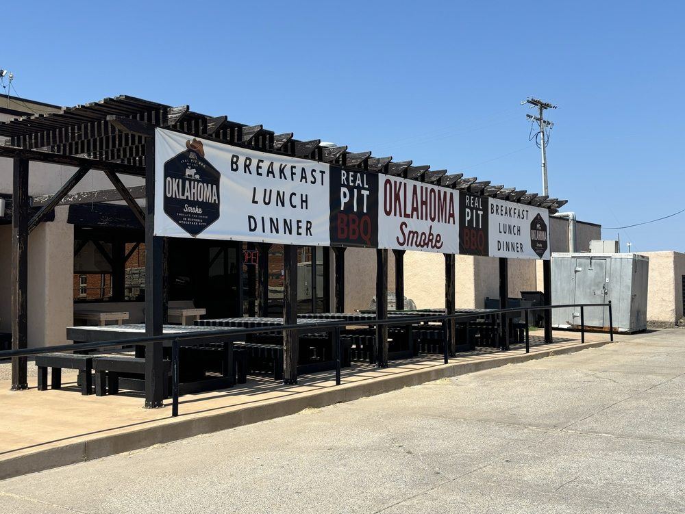 Oklahoma Smoke on West Main Street: covered patio with Real Pit BBQ and Breakfast Lunch Dinner banners