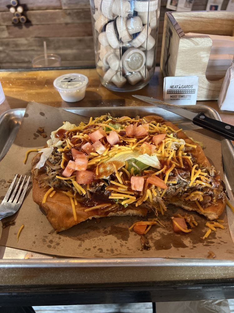 Indian taco on fry bread topped with meat, cheese, lettuce and tomato